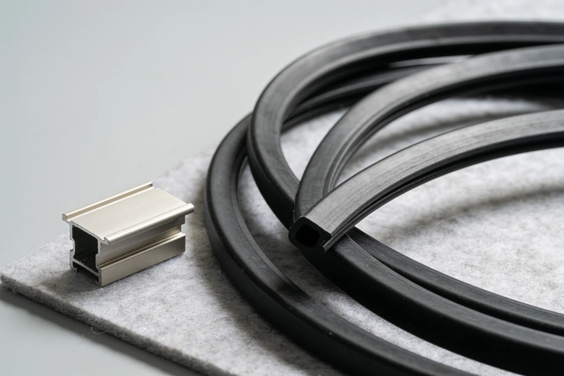 Gummiprofile für Mauerabdeckungen neben einem Stück Aluminiumprofil