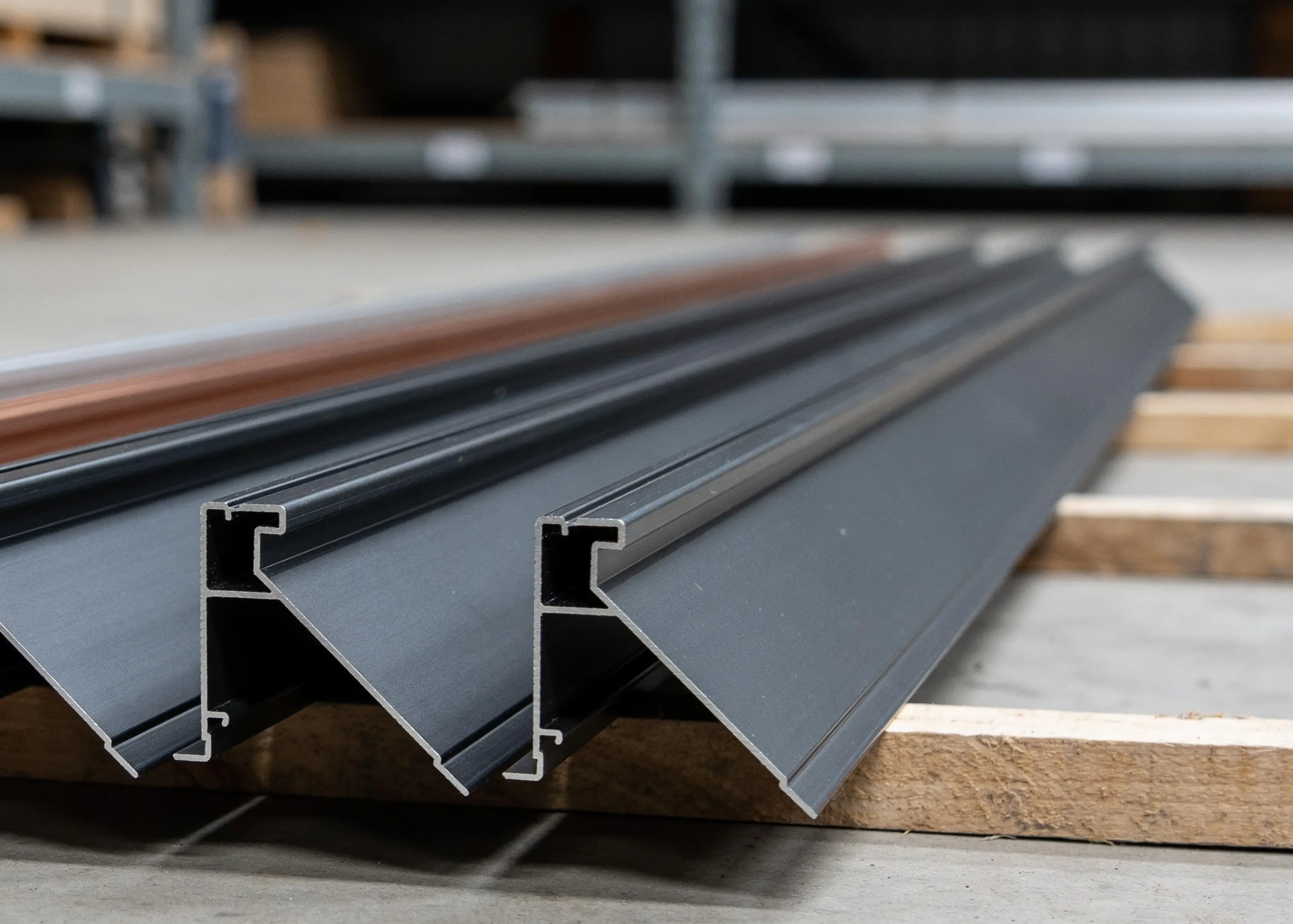 Dachrandprofile aus anthrazit beschichtetem Aluminium auf Kanthölzern, Blick auf die Querschnitte