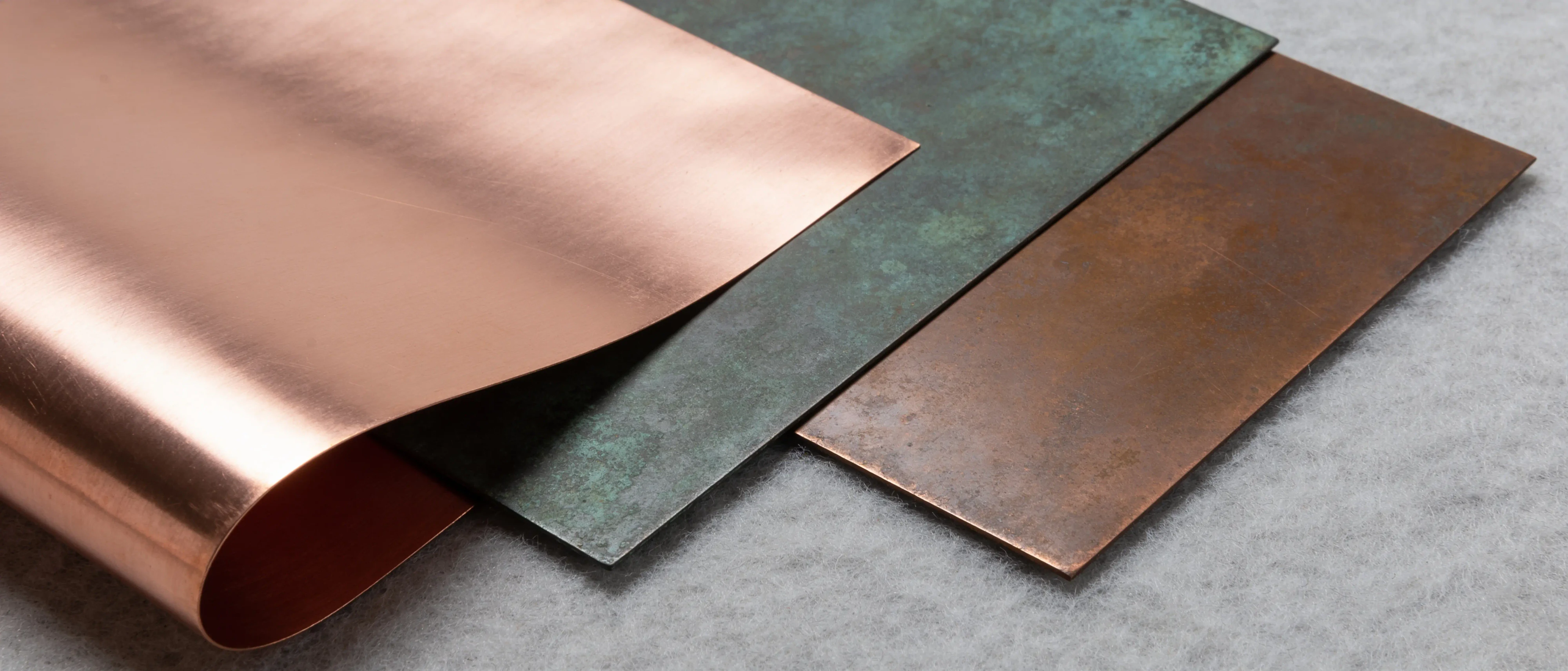 Kupferbleche walzblank, oxidiert und mit Patina überlappend nebeneinander