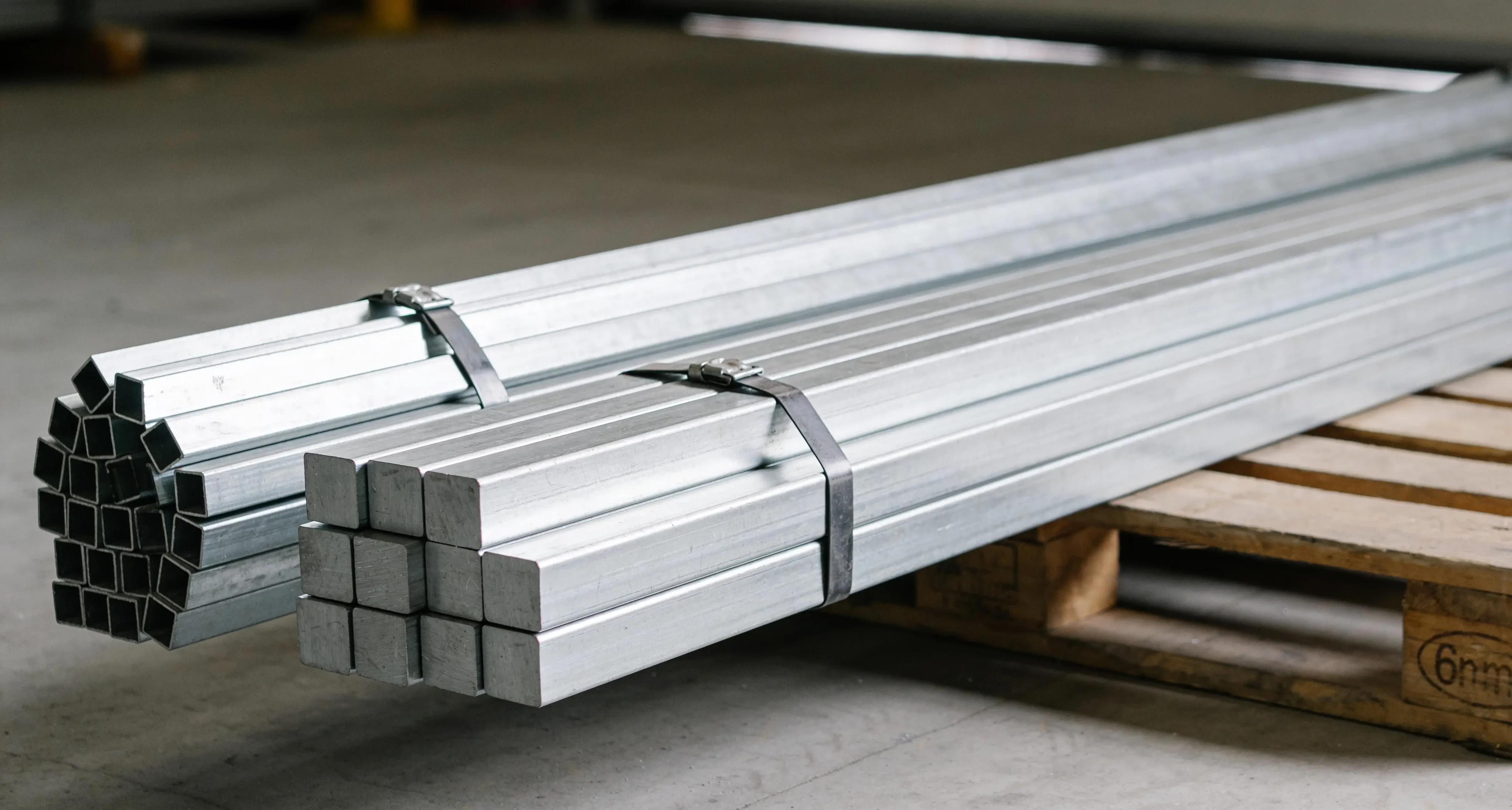 Umreifte Bündel aus Aluminiumrohren und Vierkantstangen auf einer Palette