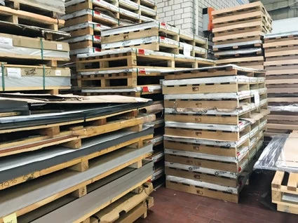 Gestapelte Blechtafeln auf Paletten im Lager